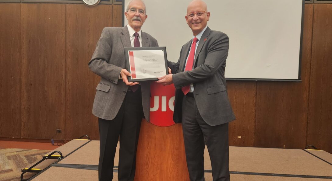 Philip Clifford (left) is presented with a certificate from the UIC College of Applied Health Sciences by Carlos Crespo at AHS Research Day 2023.