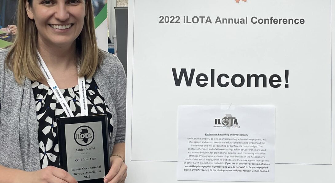 AShley Stofeel holds an 2022 OT of the Year Award plaque from the Illinois Occupational Therapy Association at the 2022 ILOTA annual conference