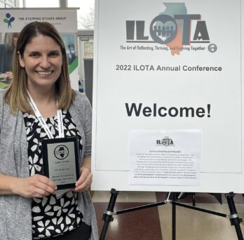 AShley Stofeel holds an 2022 OT of the Year Award plaque from the Illinois Occupational Therapy Association at the 2022 ILOTA annual conference
                  