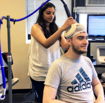 Woman scans a seated man's brain
                  