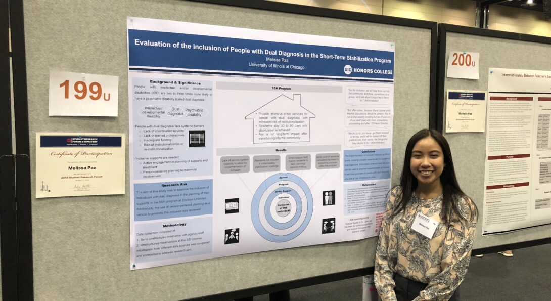 Melissa Paz stands before her research poster