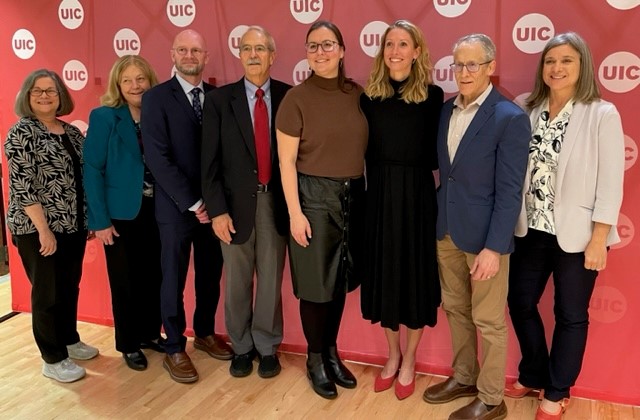 A group of eight AHS faculty members pose for a photo