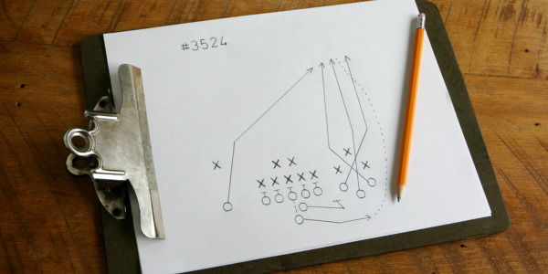Clipboard with a pencil drawing of a game play