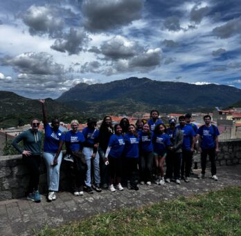 Group of students in blue UIC shirts with a back drop of mountains
                  