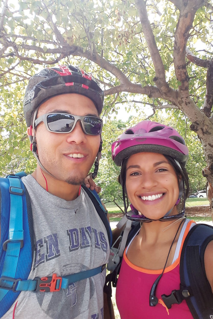 Austin Robinson and Sofia Sanchez pose for a photo with bicycle helmets on