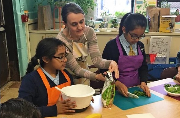 Michelle Reich opens bag with scissors in between two middle school students