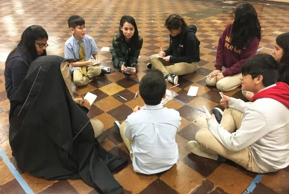 Kathyrn Marie Garrido sitting in a circle with a group of students