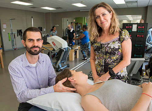 Two people taking care of a patient laying down