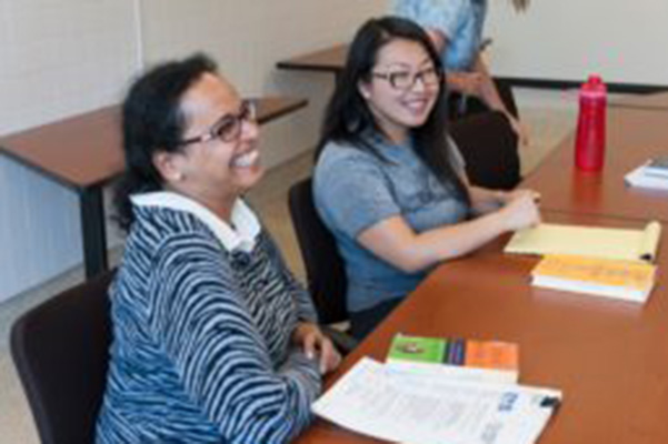 Two women sitting at a table smiling