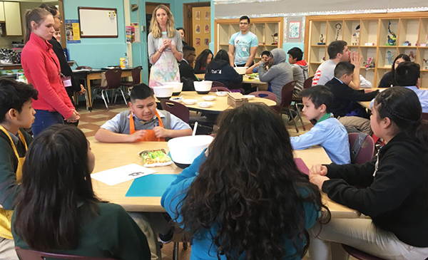 Group of students sitting at round tables in a classroom