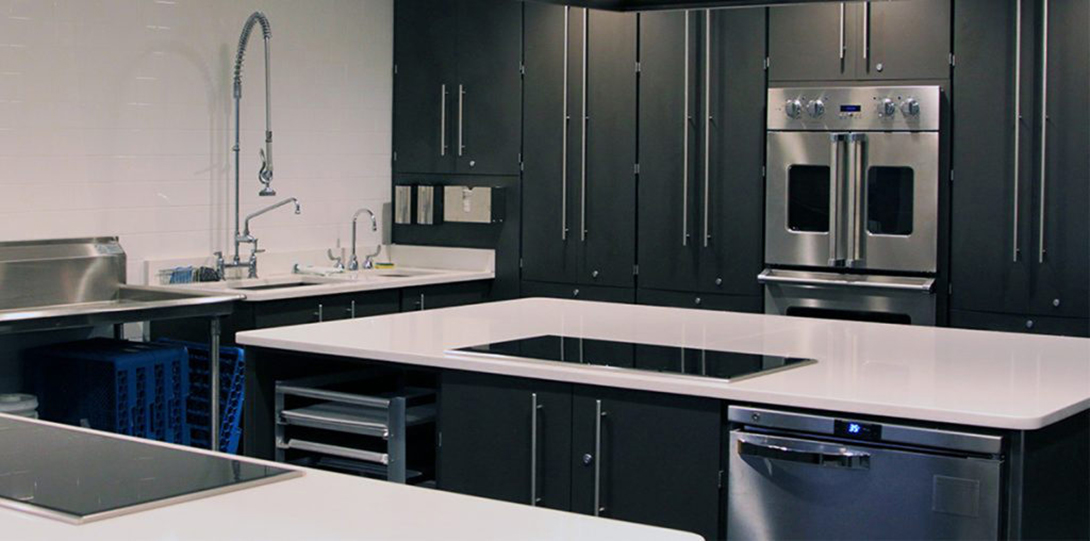 Kitchen with black cabinets and white counters