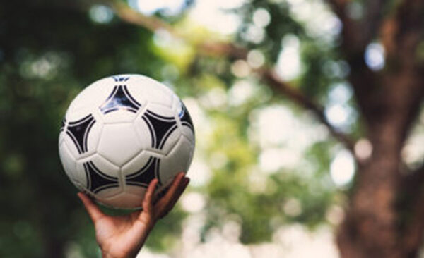 Hand reaching up with soccer ball