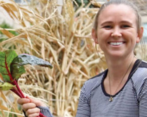 A student holding a freshly cultivated vegetable