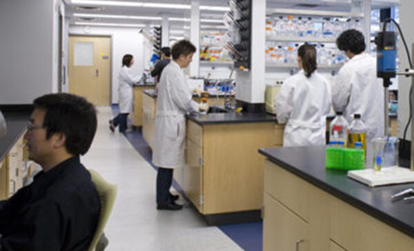 Students in lab coats working in wet lab