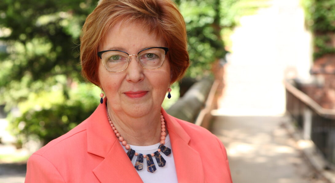 Margret Amatayakul head shot with greenery in the background