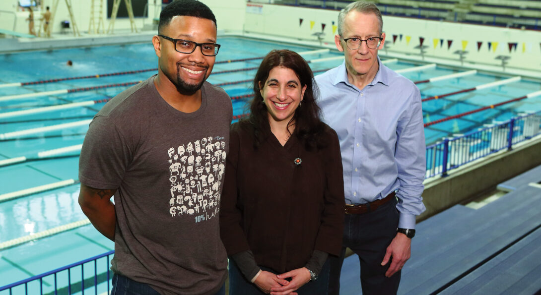 Jarrad Hampton-Marcell, Rachel Poretsky and Craig Horswill (from left to right) stand in front of an indoor swimming pool