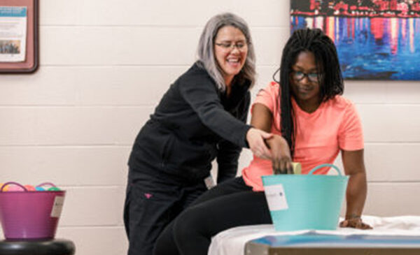 Women helping another women put things into a basket