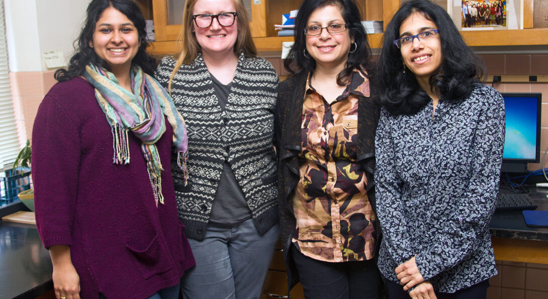 Grad students (from left) Vineeta Ram and Kathryn B. Duke work on the PRIDE project with researchers Rooshey Hasnain and Mansha Mirza. ­