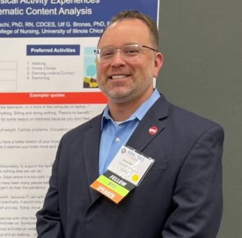 David Marquez stands next to a research poster
                  