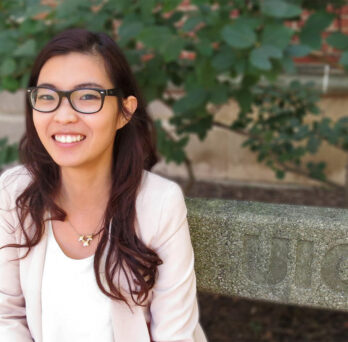 Esther Ng sitting on a bench outdoors
                  