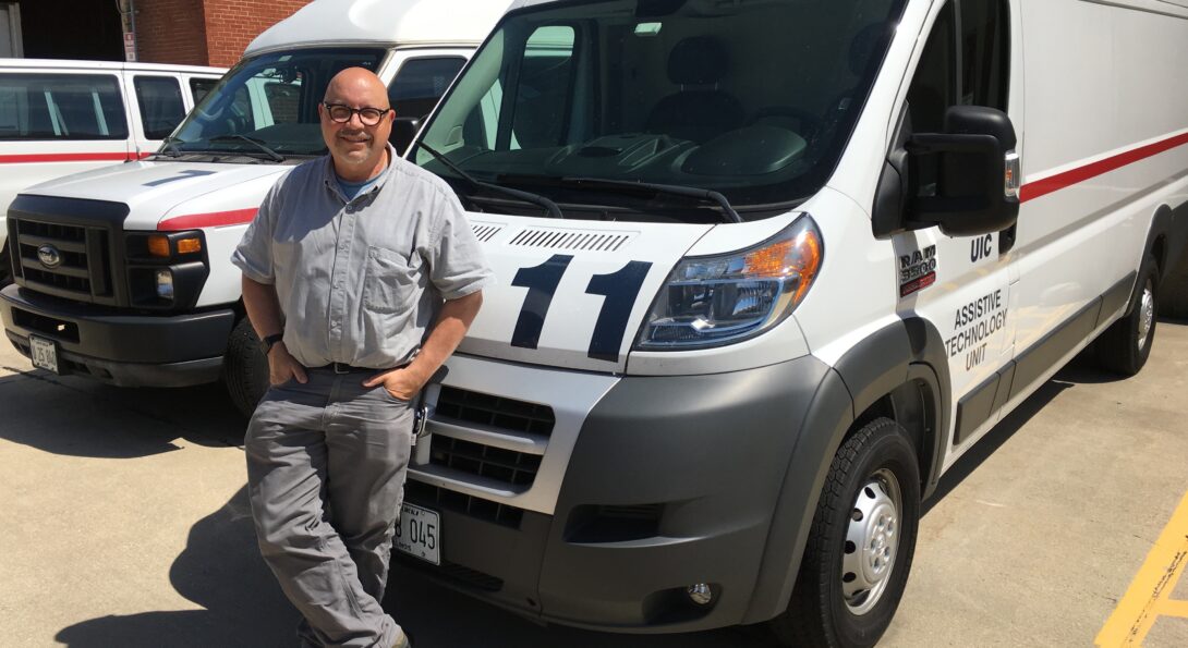 Glenn Hemann leans on an ATU mobile unit which is parked in a parking lot