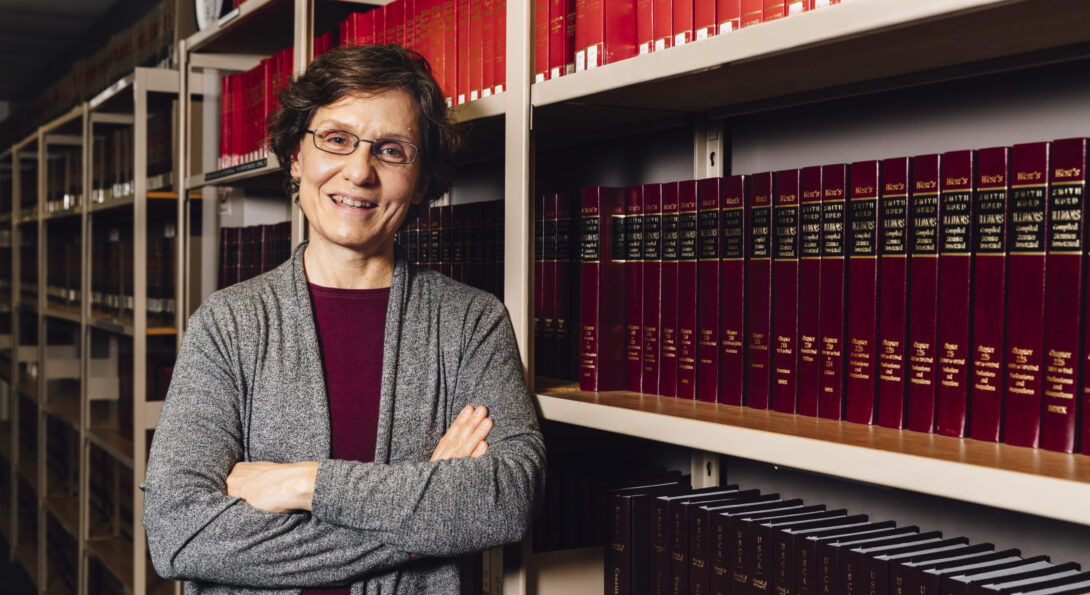 Susan Kahan stands in front of a bookcase filled with law books