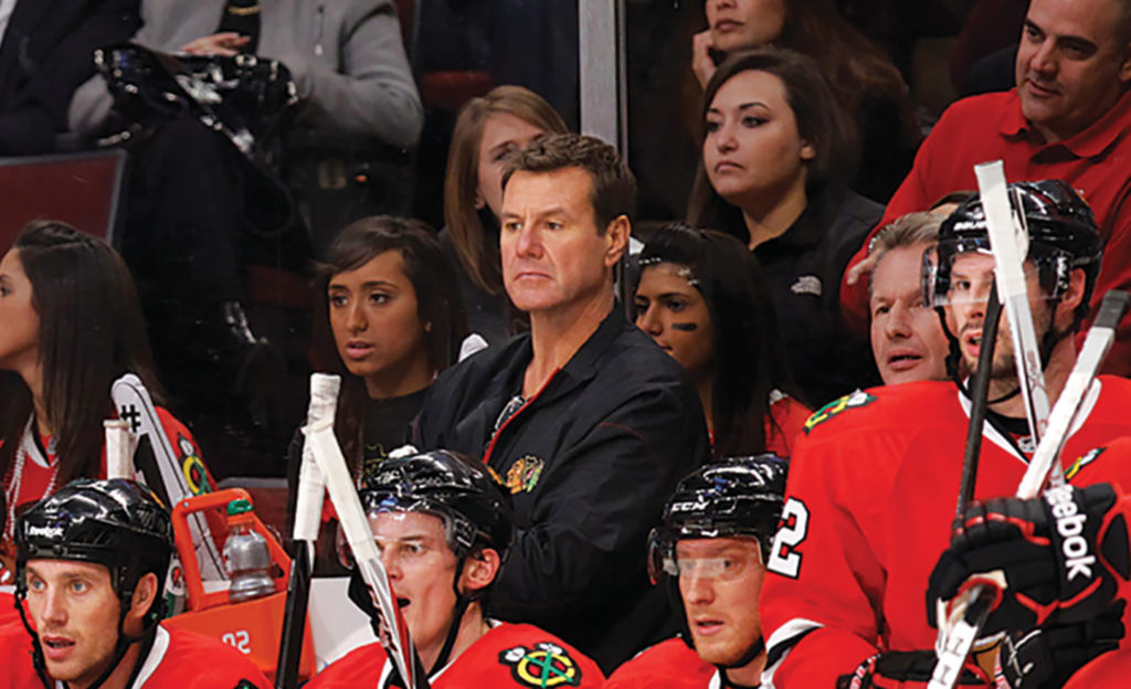 Mike Gapski standing in a crowd with Chicago Blackhawks players