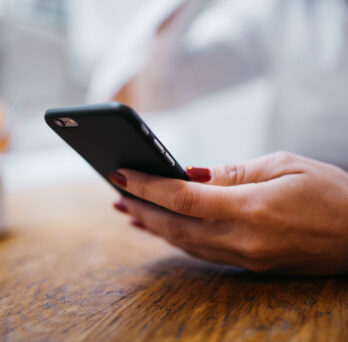 Image of woman's hand holding a smart mobile phone
                  