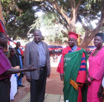 When he returned to Uganda, his village held a graduation celebration with decorations in UIC colors for Patrick Ojok, shown here with his wife, Akidi Florence.
                  