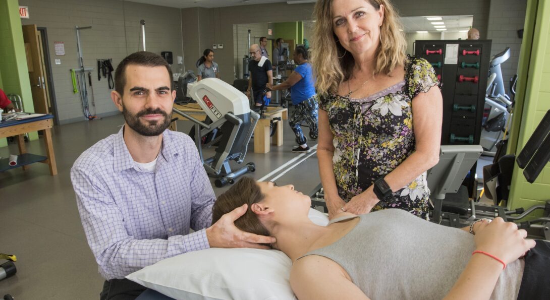 Adam Wielechowski and Deb Davey with a person on a mat table