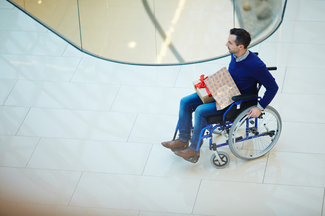 Man sitting in a wheelchair with presents in his lap