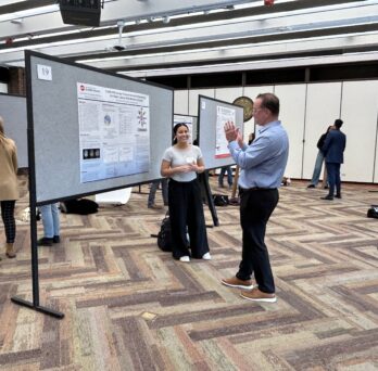 David Marquez and Mariana Pinto discussing a research poster during AHS Research Day.
                  