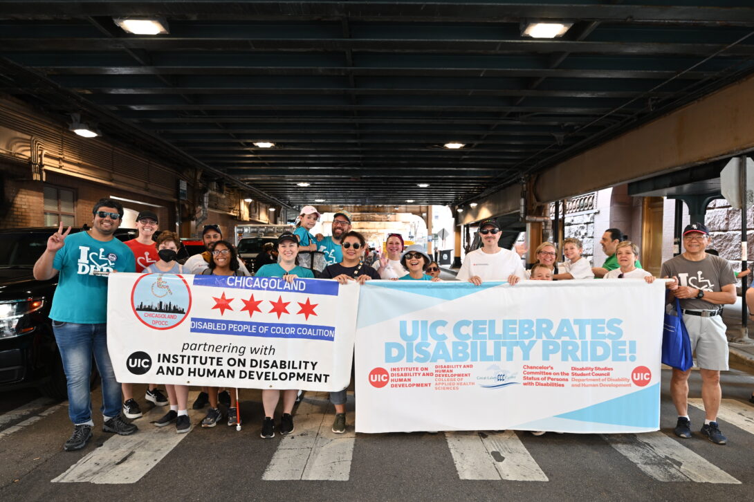 a group of people holding a banner that says UIC celebrates disability pride