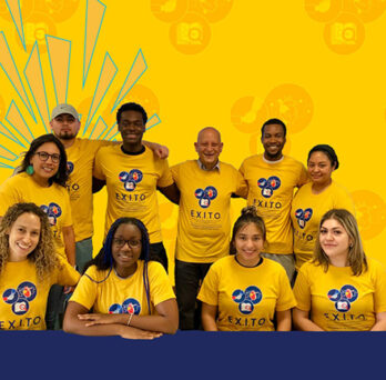 EXITO members wearing yellow shirts in front of a yellow background
                  