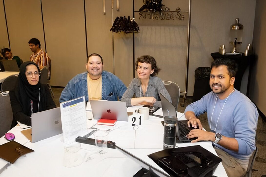 Mohan Zalake (far right) and team sitting at a round conference table.