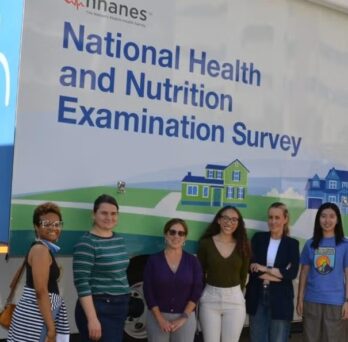 AHS and SPH faculty and staff stand in front of the NHANES mobile examination center.
                  