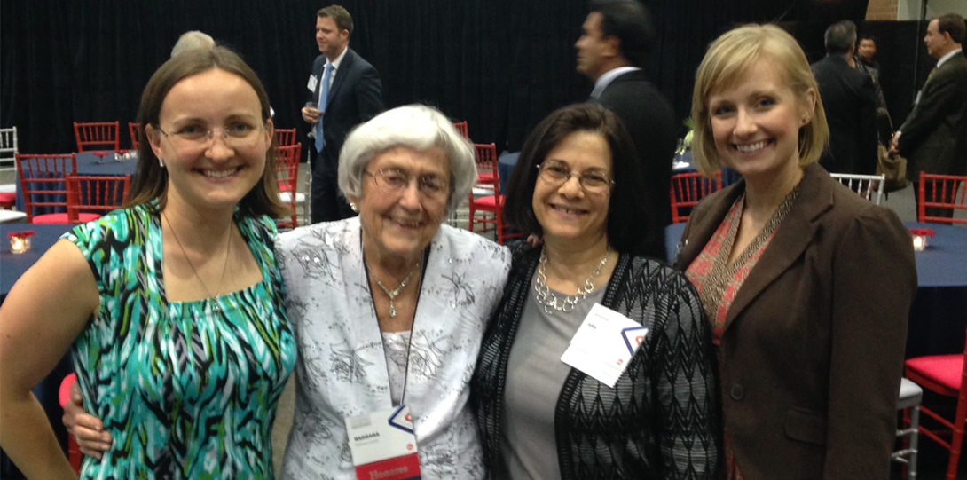 A group of 4 women standing and smiling at the camera